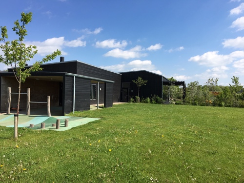 På billedet ser du en del af daginstitutionens bygning i Lund Børnehus og et legeområde